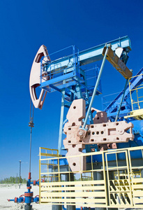 石油和天然气工业。在沙漠油田的油泵千斤顶工作。蓝天