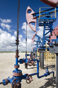 石油和天然气工业。油泵千斤顶在油田的工作。管道上的油闩锁