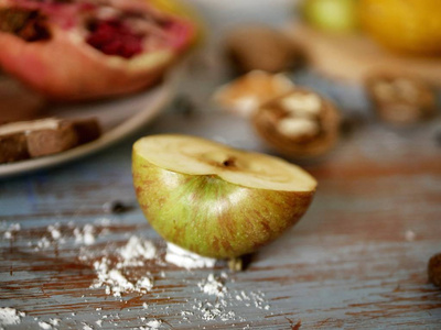 半个新鲜的青苹果放在木桌上, 以蔬菜和水果为背景, 准备健康食品
