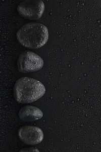 黑石头躺在湿的黑色背景