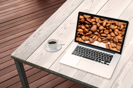 笔记本电脑在桌子上的厨房与咖啡豆在屏幕上, 厨房的概念