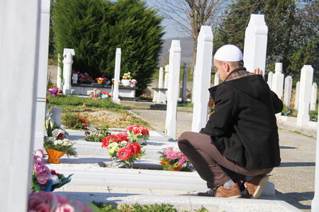 年轻的穆斯林男子靠近了他父亲的坟墓