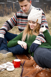 年轻夫妇野餐。幸福情侣坐在一起享受公园的乐趣