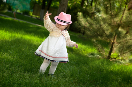 一个戴着帽子的小女孩在公园里玩