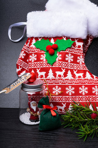 圣诞节鹿丝袜与礼物礼物, 分支与浆果在木背景