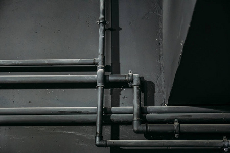 黑色墙背景上的黑色管道作为抽象的工业管道纹理