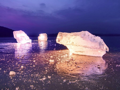 冰冷的石头铺设在黑色的光亮和破碎的冰面上照片