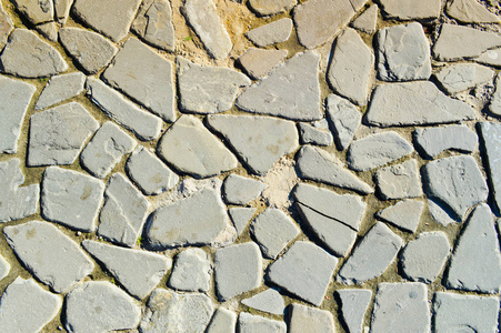 石路的质地, 人行道, 大灰色的旧中世纪圆形强石, 鹅卵石的墙壁。的背景
