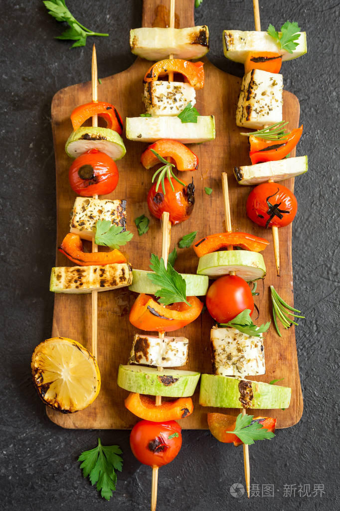 素食烧烤素食串与halloumi乳酪和蔬菜在黑背景复制空间
