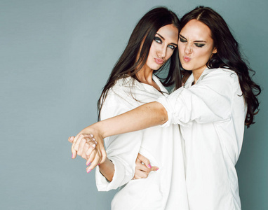 两姐妹双胞胎构成，制作照片拍照，穿着相同的白色