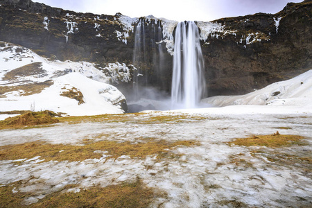 冰岛地标的大 Seljalandsfoss 瀑布在冬季设置雪和冰