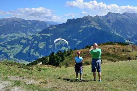 游客期待着滑翔伞飞越美丽的山脉和山谷