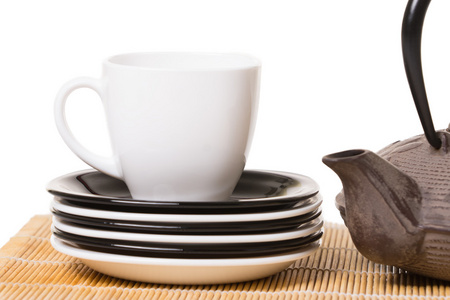 白杯茶上不同的碟子上木制, 的铁茶壶