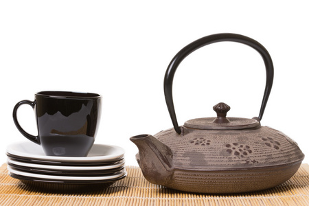 黑色杯茶上不同的碟子上木制, 的铁茶壶