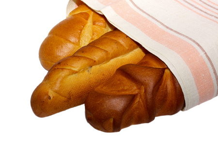 长条面包将切开李子蛋糕向蛋糕盘子和白色的木材木板长条面包.