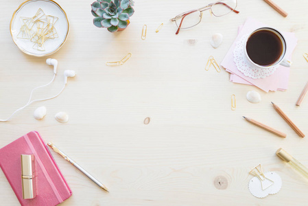女性家庭办公桌在柔和的口气。工作空间与笔记本, 咖啡杯和装饰在轻木背景与复制空间。平躺, 顶部视图