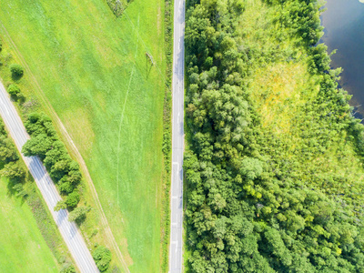 公路鸟瞰图。在湖边一条乡间小路的鸟瞰图。车经过。空中公路。空中鸟瞰飞行。从上面捕获的无人机。柔和照明