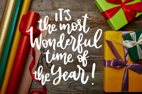 在包装纸的整理的顶部视图, 新年呈现与丝带和剪刀在木桌面与 这是一年中最美好的时间 的灵感