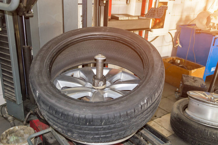 汽车车轮半从磁盘上执行轮胎安装和安装在一个特殊的机器在车间修理车辆在冬季开始前的季节