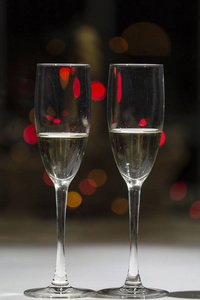两杯香槟, 在背景灯的典型圣诞颜色转换成彩色点