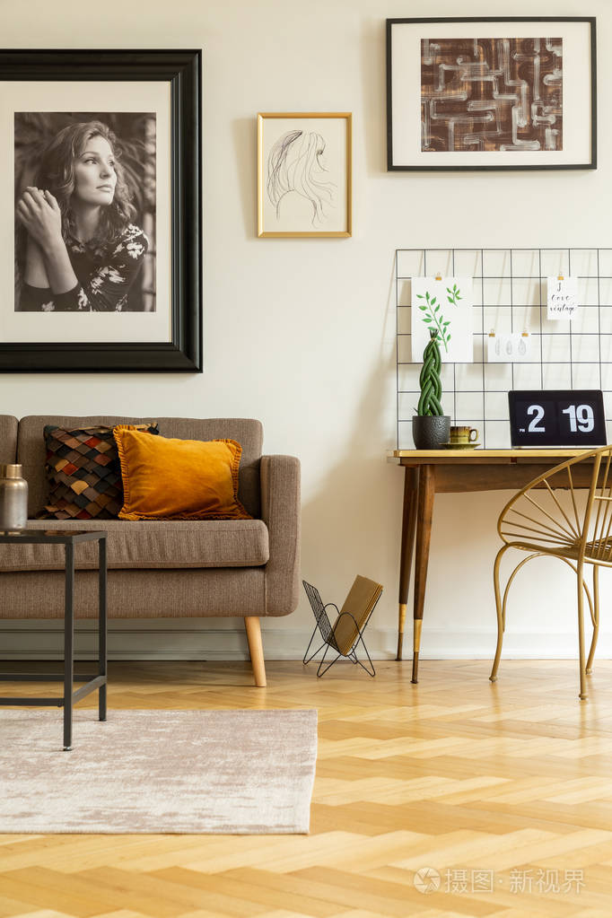 海报以上的沙发旁边的椅子和办公桌与笔记本电脑和工厂在工作区内部.