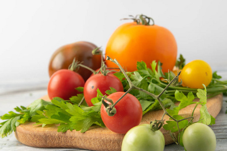 从草甸到餐桌的自制西红柿是不同颜色和大小的天然混合。在木板和勺子上呈现