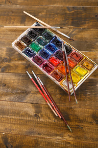 色彩缤纷的水彩和木制的背景的画笔