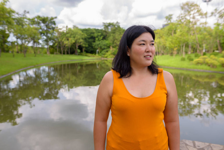 美丽的超重亚洲妇女在公园思考