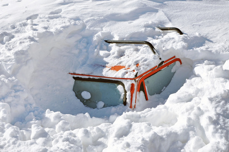 雪覆盖在冬季暴风雪中的车