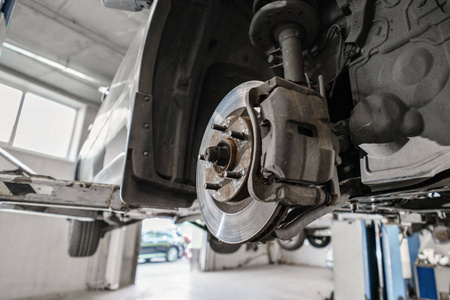 汽车机械检查车车轮和维修暂停细节。在维修服务站提升汽车。更换套圈和杠杆