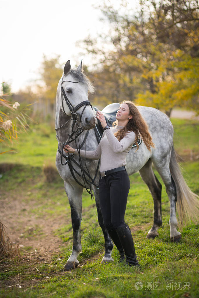 带着马散步的年轻女子