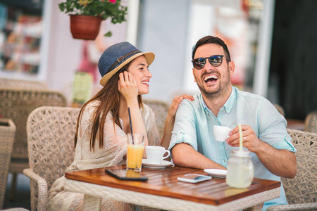 美丽的情侣坐在咖啡馆里, 在咖啡里享受着交谈照片