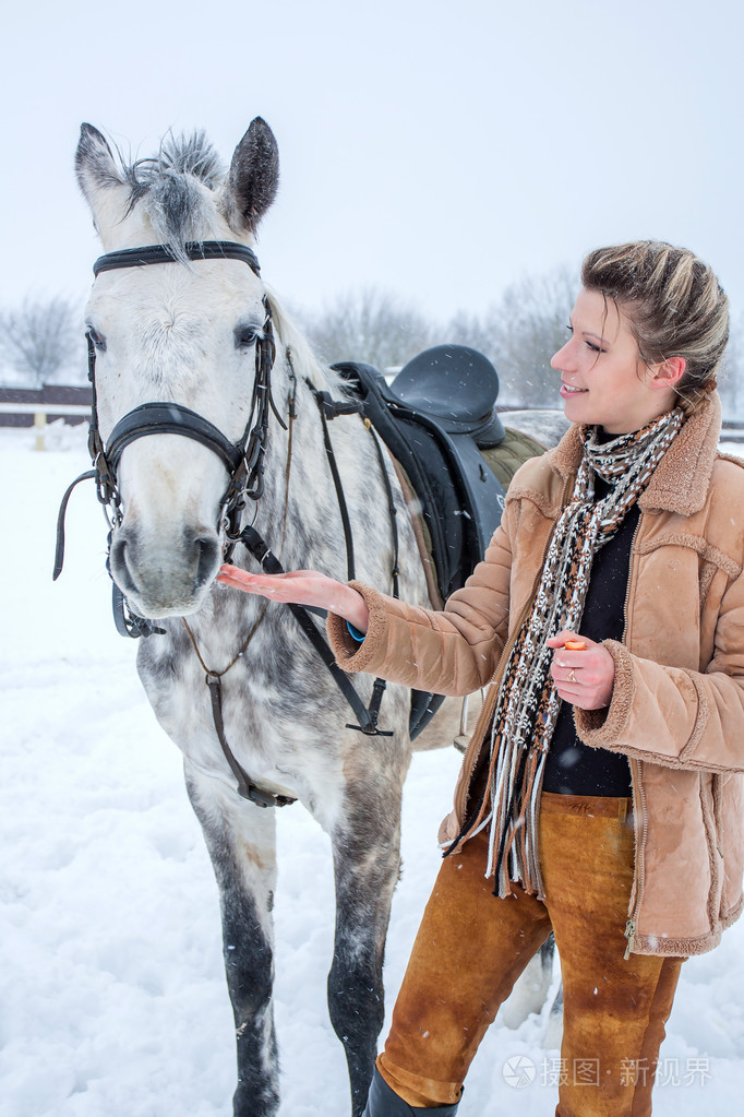 一个女孩与一匹马在冬天雪地上
