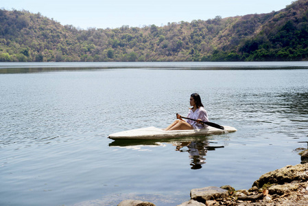 亚洲女士在撒旦岛的湖面上划着皮划艇。印度尼西亚苏姆巴瓦
