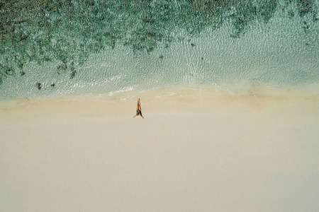 空中无人机鸟瞰美丽的女孩在阳光明媚的热带海滩上享受乐趣。塞舌尔