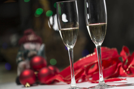 两杯香槟, 在背景中的圣诞节气氛在红色色调, 温暖的家