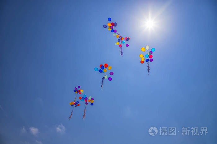 在蓝天飞行的多色氦气球。婚礼庆典纪念日娱乐的概念