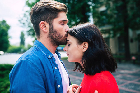 异性恋妇女年轻男子亲吻妇女额头上照片