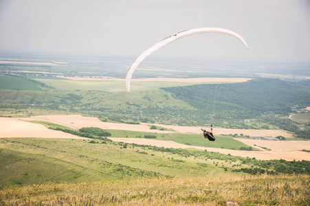 白色橙色 paraglide 与滑翔伞在茧的背景下的天空和云层。滑翔运动