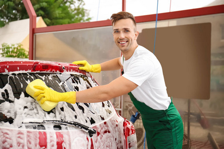 在洗车时用海绵清洗车辆的男工人