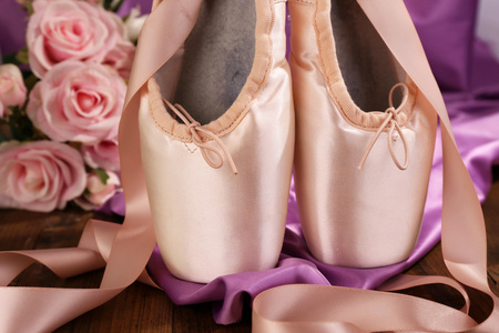 芭蕾舞团备脚尖鞋在木制地板上织物背景