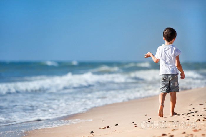 热带沙滩散步的小男孩