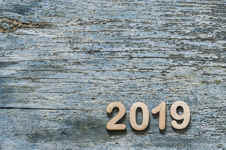 新年概念2019 号, 由木制数字排列在一个蓝色的木桌上。复古风格的背景