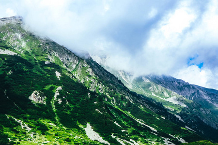 美丽的高山山峰, 多云, 有雾。令人惊叹的绿色丘陵景观, 夏季