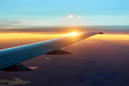 早晨日出与机翼的飞机.旅行概念照片