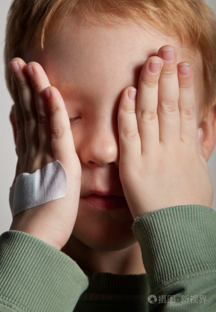悲哀哭泣的小男孩画像遮住了脸与手