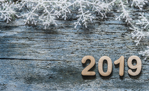 新年快乐2019。蓝色木质背景上的2019号符号