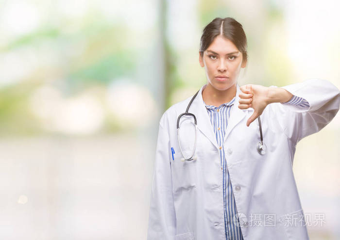 年轻的西班牙裔医生与愤怒的面孔消极标志显示不喜欢与拇指下来拒绝