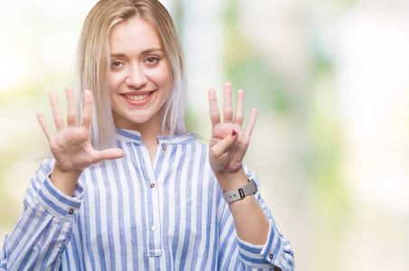 年轻的金发女人在孤立的背景显示, 并指出手指数九, 而微笑着自信和快乐
