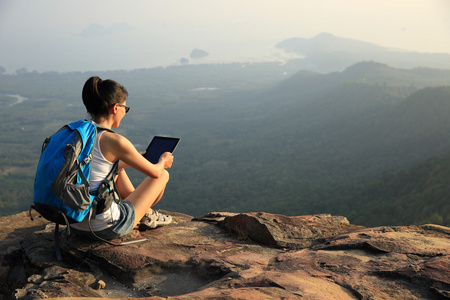 徒步旅行者在山顶 tablet pc 上